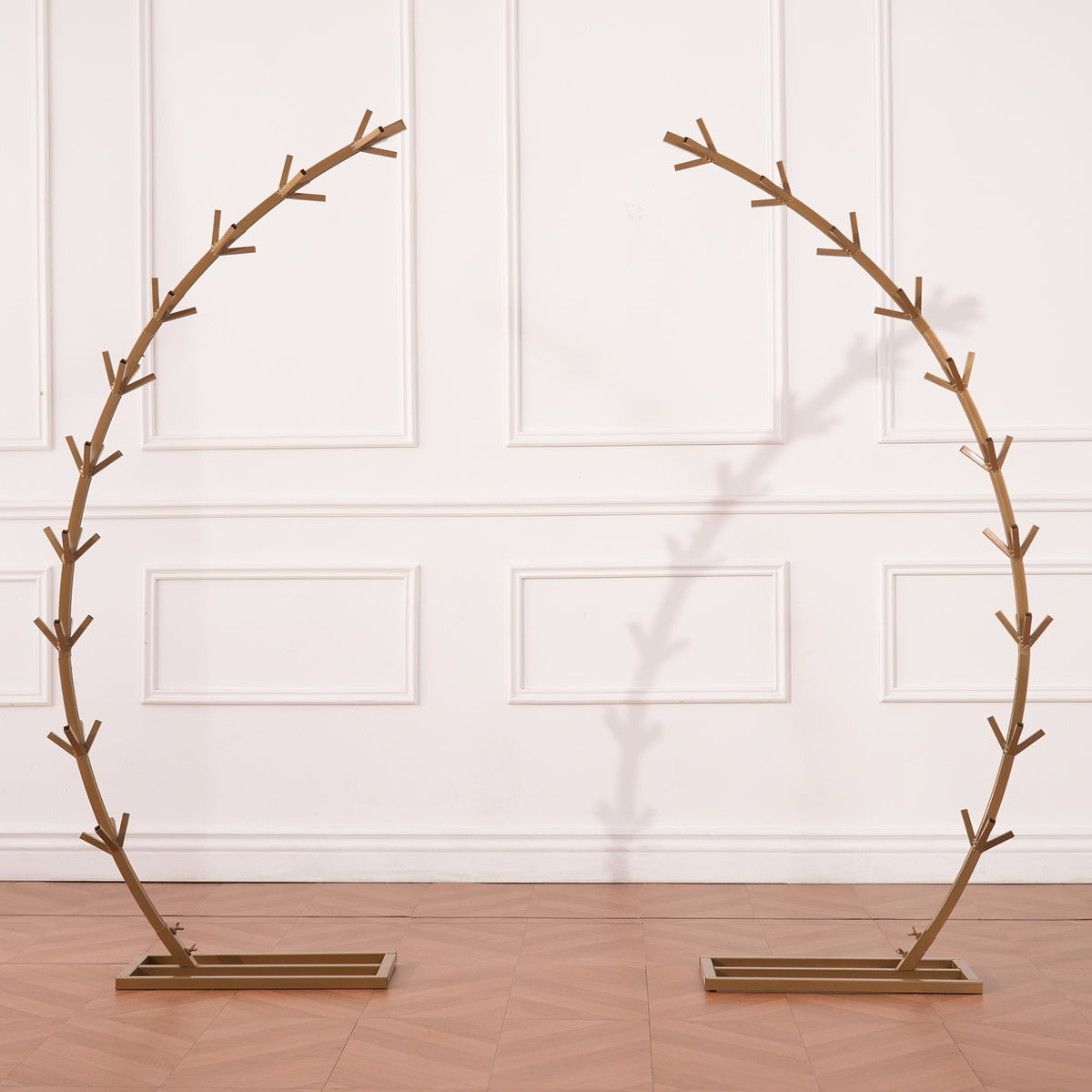 empty golden circular metal wedding arch frame on wood floor