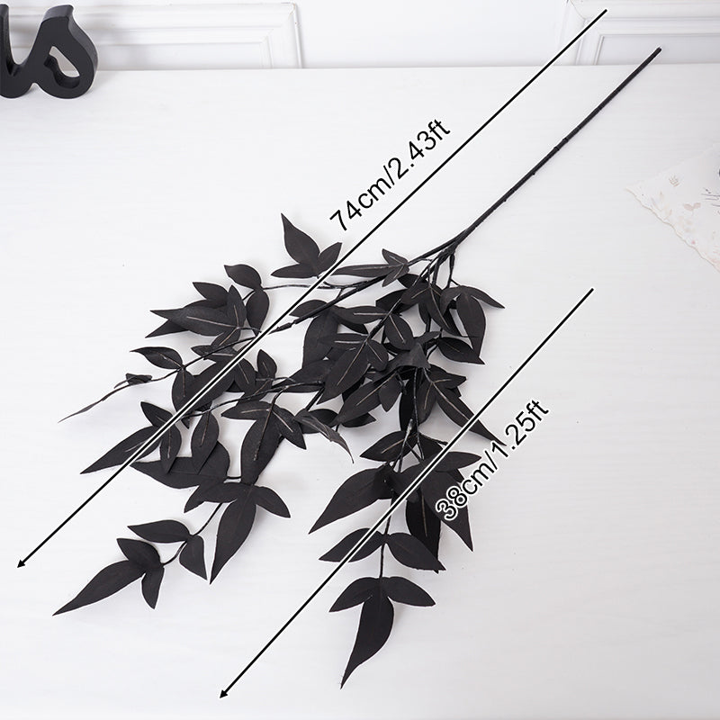 Single stem black artificial foliage branch studio shot
