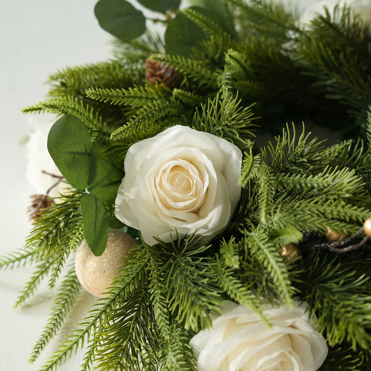 Dried pine cone accents on artificial Christmas table wreath