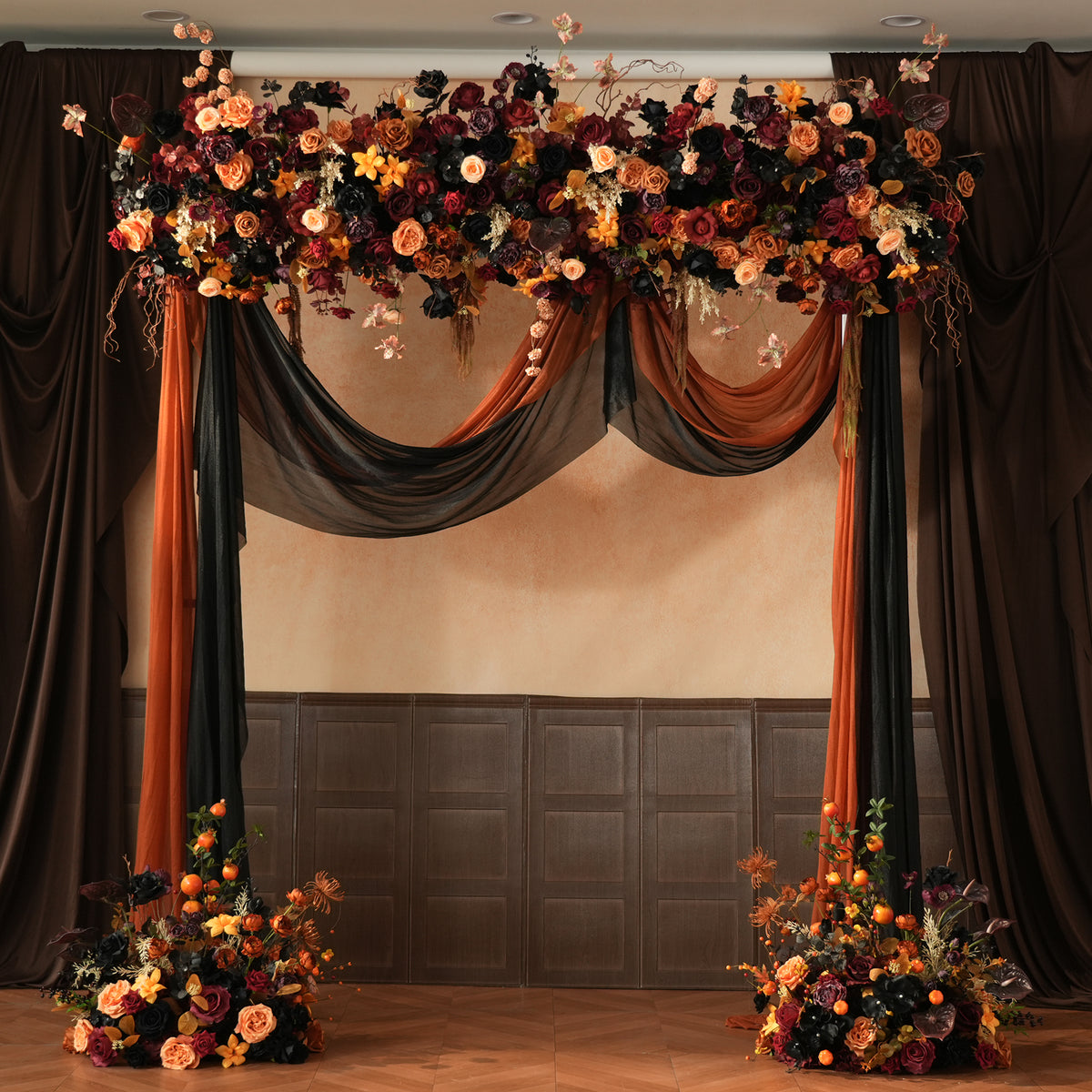 Wedding arch combo of orange black drape and floral garland