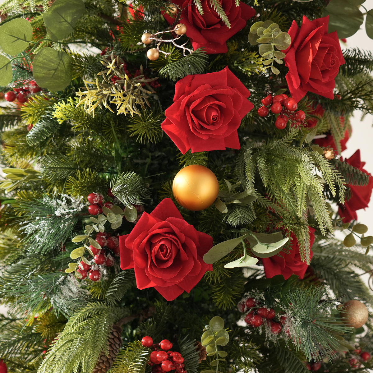 Pair of candle holder christmas table florals with red roses, evergreen foliage and gold ornaments