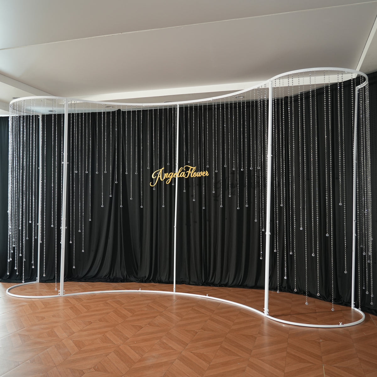Cream swag drape styling on curved wedding arch frame