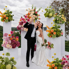 Wedding couple portrait with bright colorful table floral arrangements