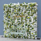 Dense mixed‑bloom fake flower wall, white ivory blooms with green foliage for wedding ceremony photo background