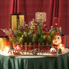 Close up of frosted artificial cedar branches, red berries and pine cones holiday greenery