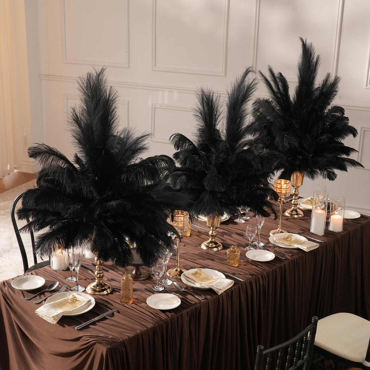 Sunset outdoor wedding tablescape decorated with tall red ostrich feather centerpieces