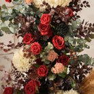 Outdoor bridal shot KT backdrop board accented with pampas grass and deep‑red artificial florals