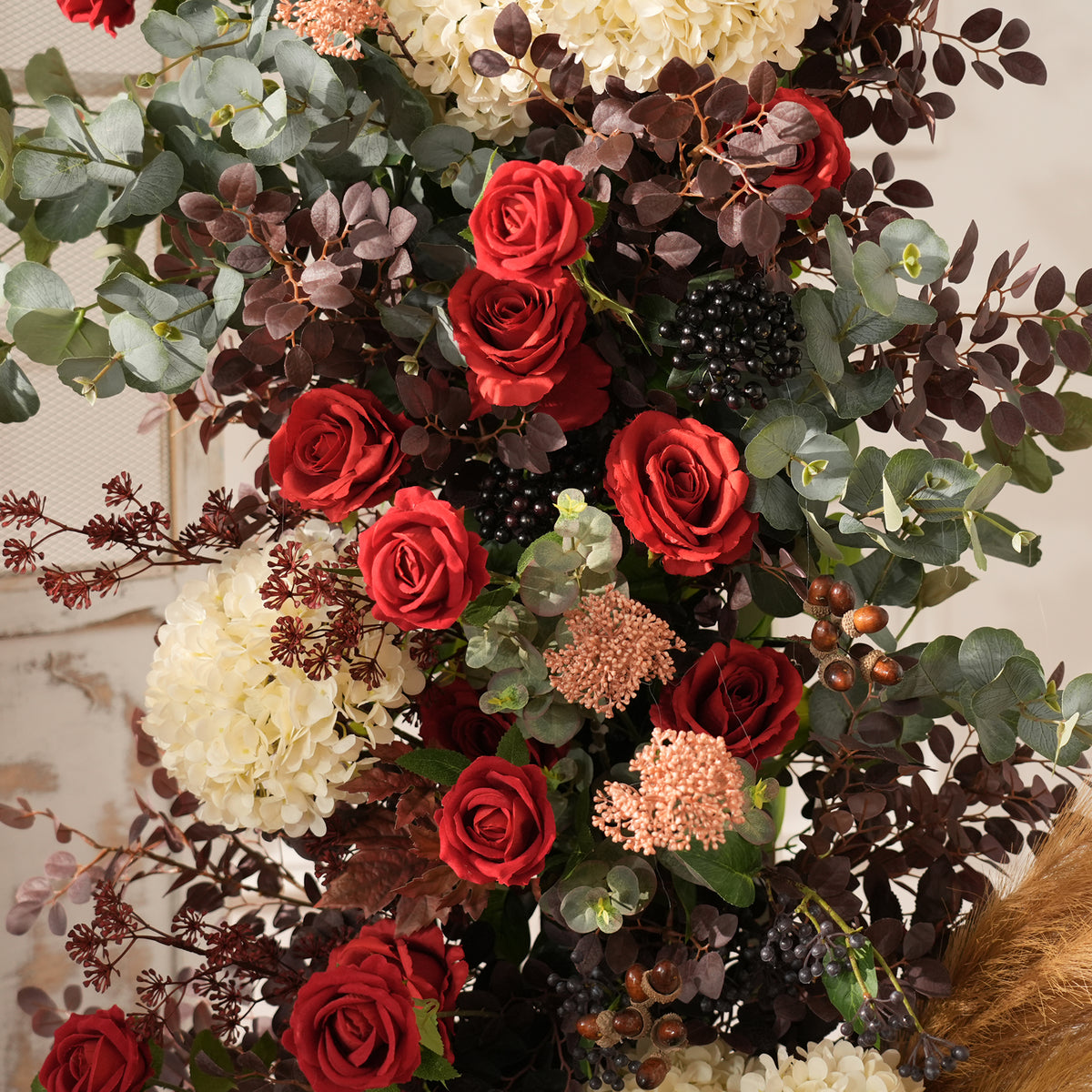Outdoor bridal shot KT backdrop board accented with pampas grass and deep‑red artificial florals