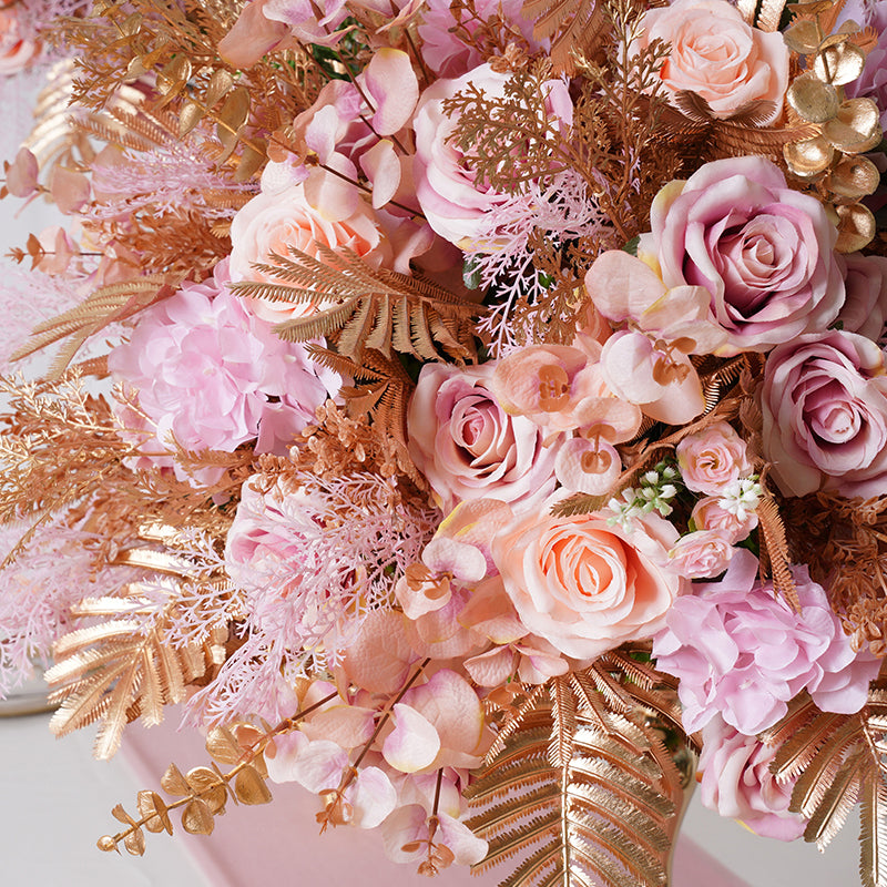 Blush flower centerpiece shot against white panel wall