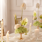 Artificial table centerpiece beside glass candle lamp home styling