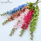 multicolor‑artificial‑delphinium‑stems‑flat‑lay‑white‑background