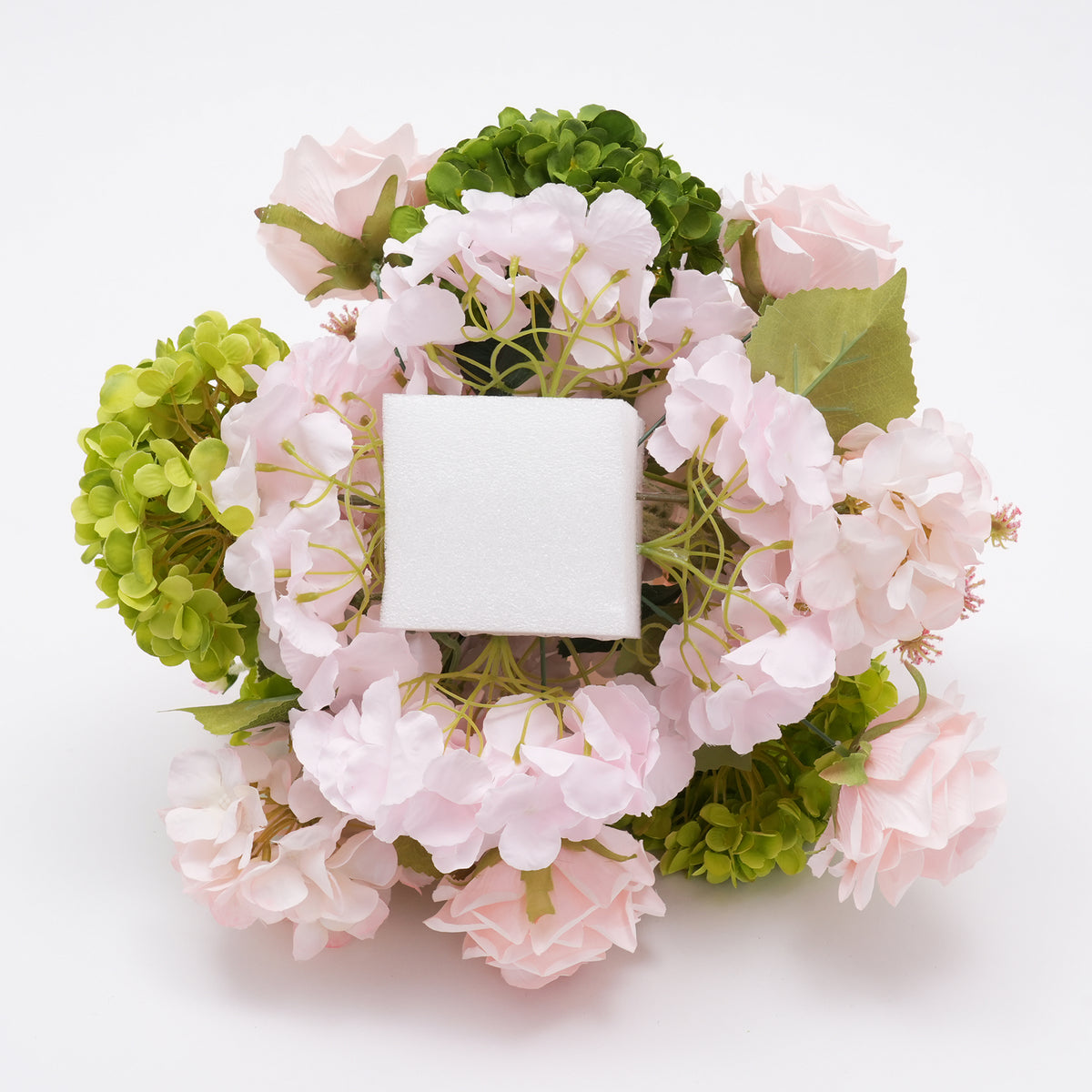 Bright green hydrangea combined with blush roses and pink poppies for event table decoration