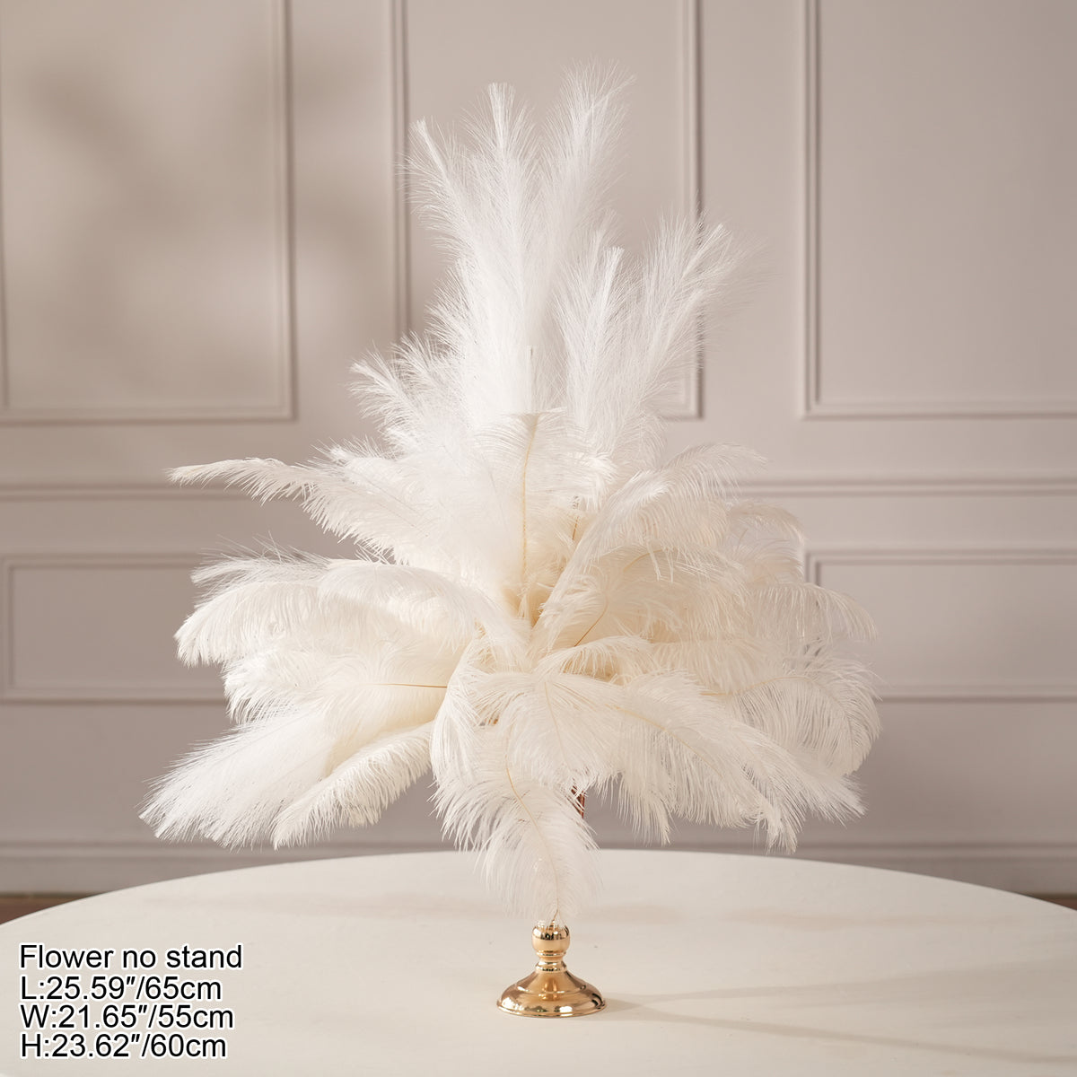Ivory ostrich feather centerpiece paired with candle and glassware on dark table