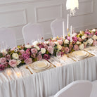 Indoor banquet wedding tablescape with long trailing mauve purple flower runner 