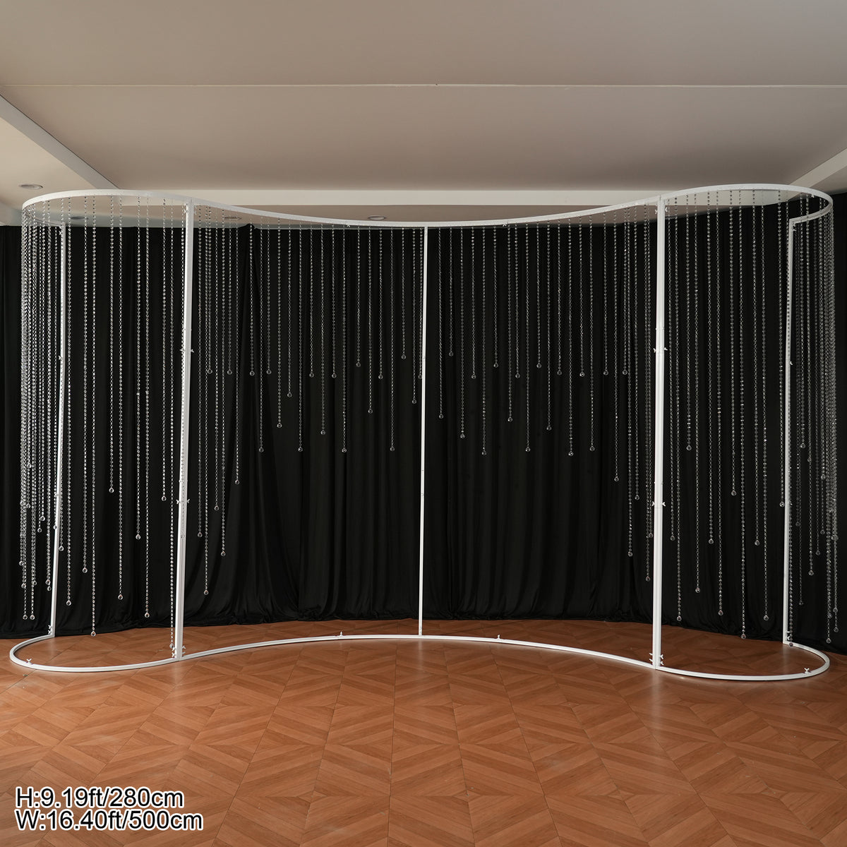 Wedding backdrop styled scene with round white stage plinth and tall candlesticks