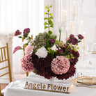 Long wedding dinner table styled with moody burgundy blush faux floral arrangements