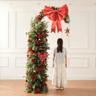 Winter floral swag with orange dried pods, long pine needles, red berries and artificial red roses