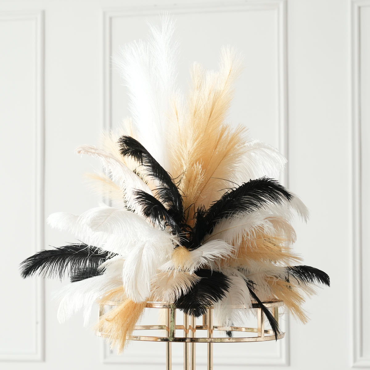 ostrich feather plumes arranged in gold pedestal vase
