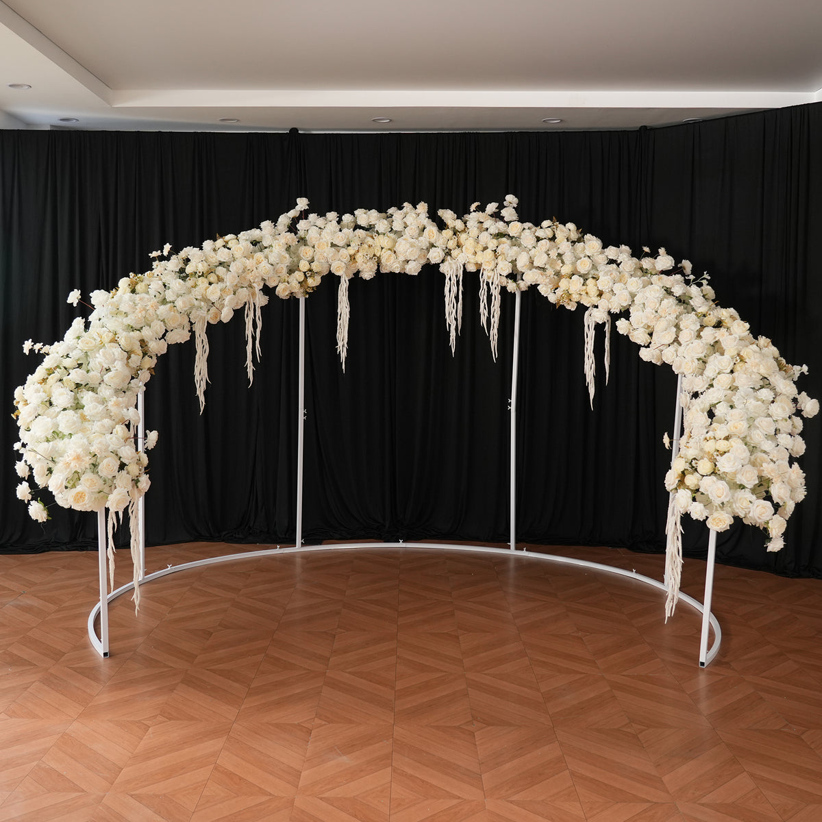 Luxury outdoor wedding scene with full white rose arch and aisle flowers
