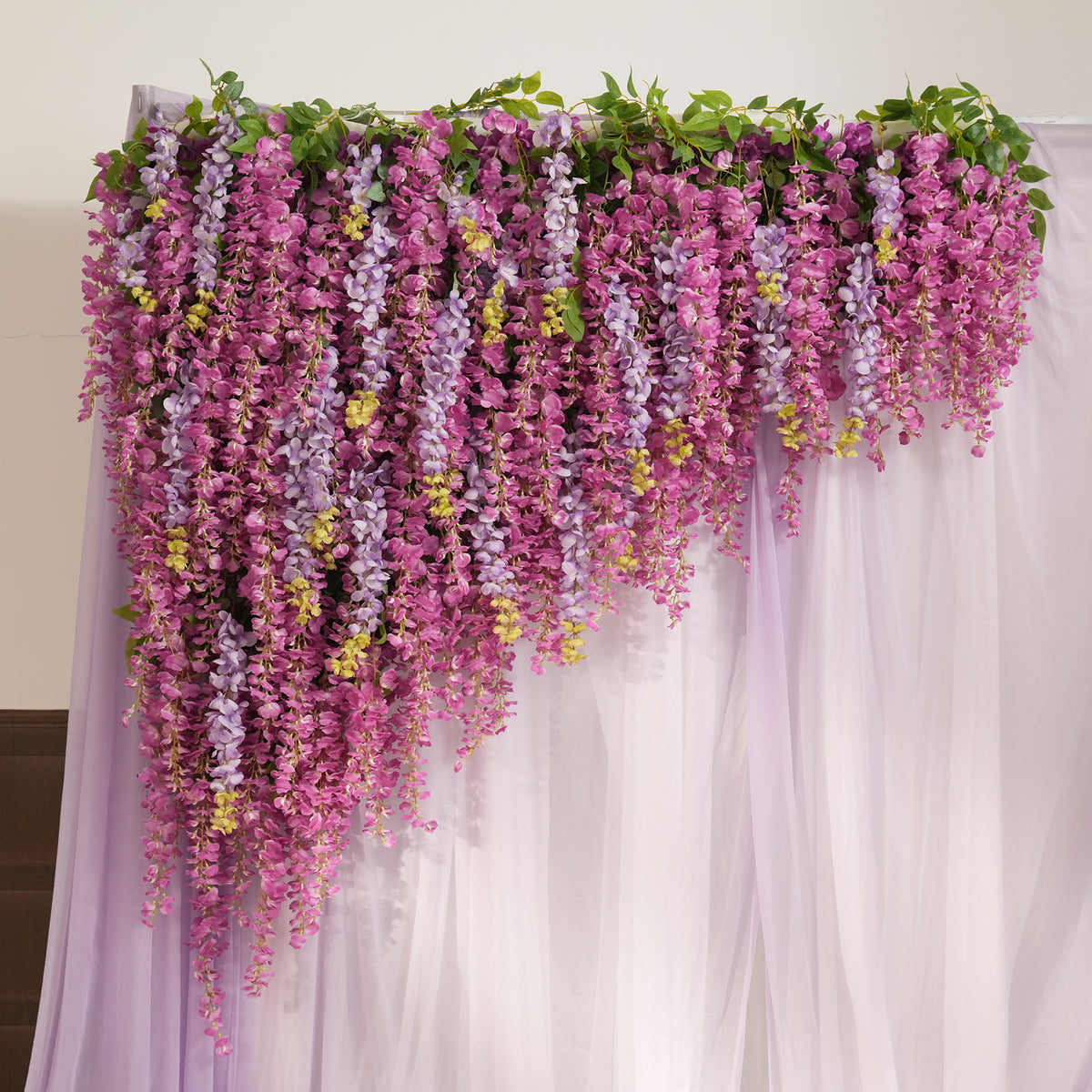 Outdoor garden wedding scene with wisteria backdrop and flower lined aisle
