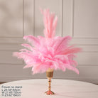 Pastel pink ostrich feather arrangement placed in glossy gold decorative vase
