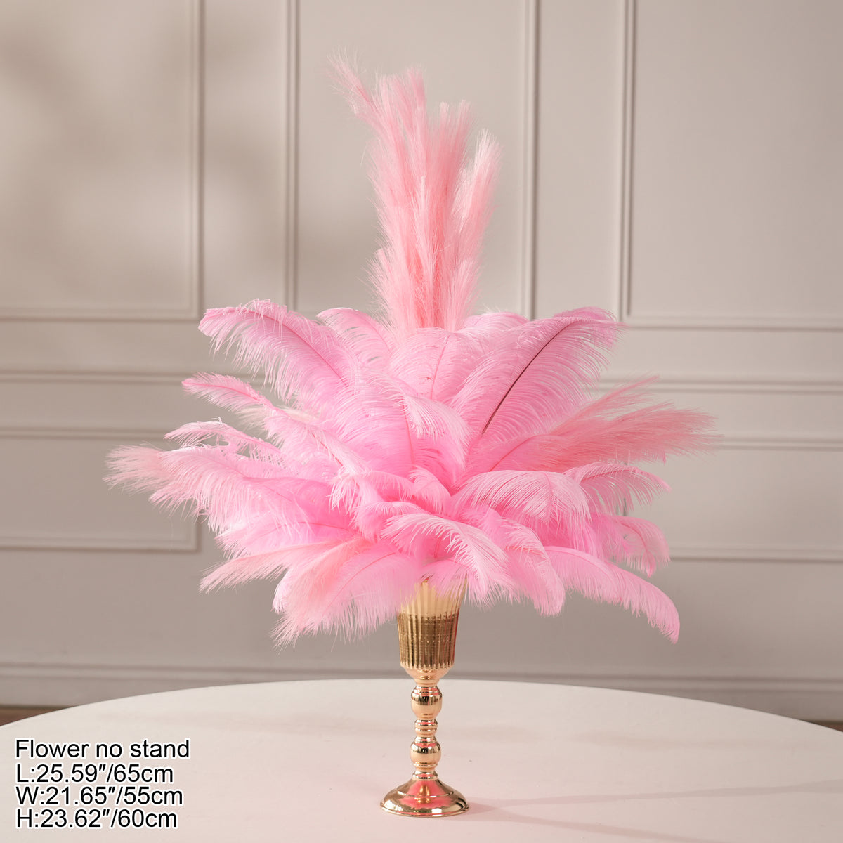 Pastel pink ostrich feather arrangement placed in glossy gold decorative vase