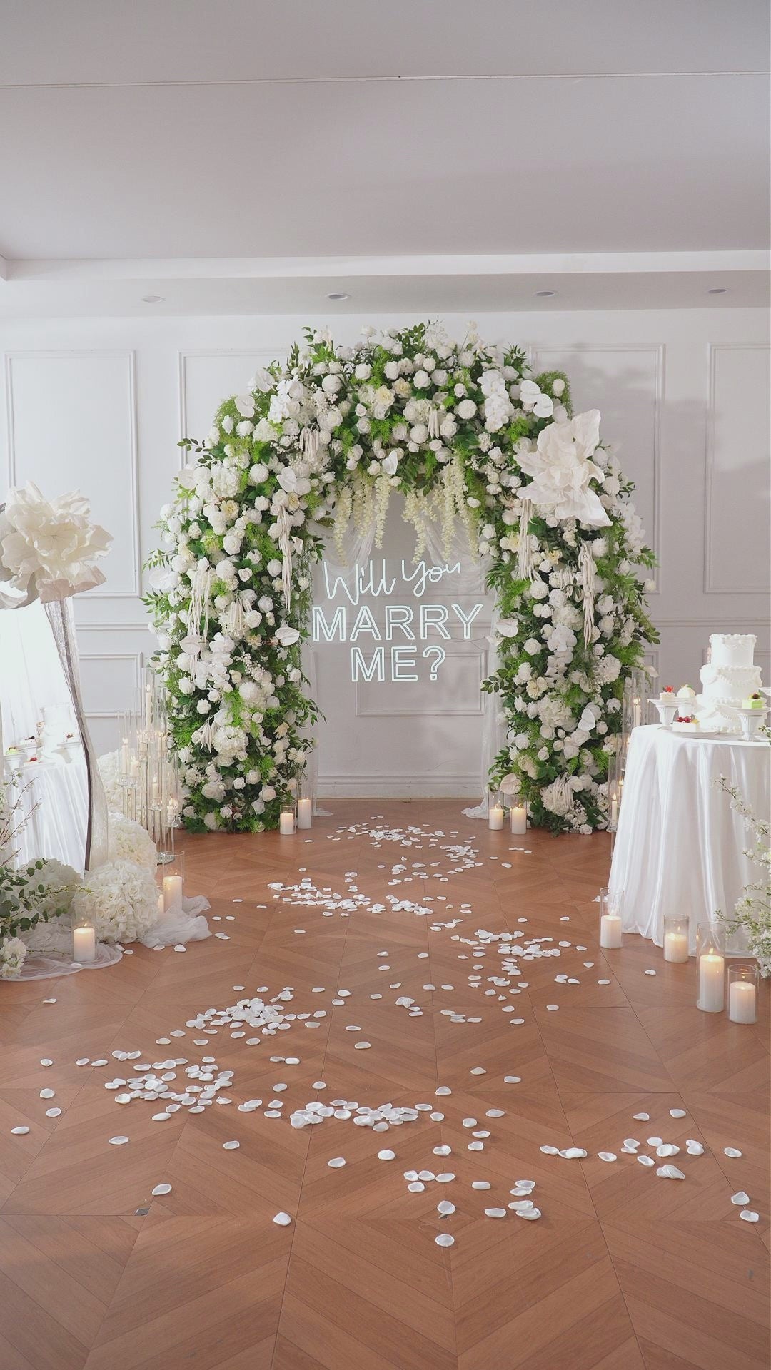 Elegant indoor wedding backdrop with full white green flower arch