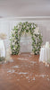 Elegant indoor wedding backdrop with full white green flower arch