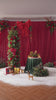 Outdoor holiday display of red rose floral hoop arch with gift boxes and candle decor on lawn