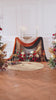 Barn‑style wedding ceremony KT panel with flowing wine‑red silk drapes and autumn artificial blooms