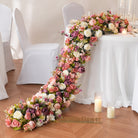 Indoor wedding reception setup with long trailing faux floral runner 