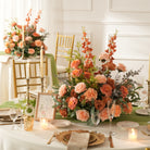 Peach rose table arrangement paired with terracotta fabric sash for wedding head table