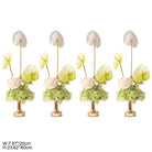 Floral centerpiece arranged in glossy gold compote vase