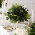 Faux palm frond and round eucalyptus table arrangement for tropical themed events