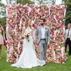 Flower wall backdrop assembled outdoors for wedding reception photography