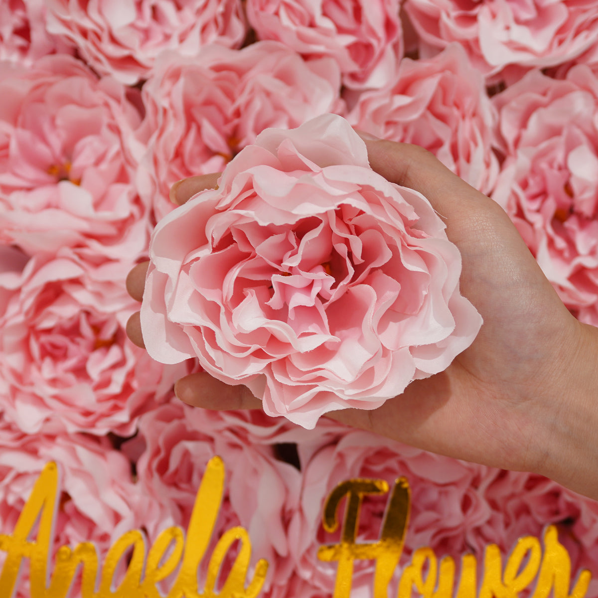 Artificial peony heads on wooden tray
