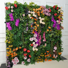 Dense greenery base flower wall with pop colorful blooms