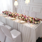 Outdoor garden wedding long table setup with cascading mauve purple faux flower runner