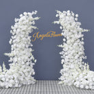White curved floral arch decorated with lanterns and wedding signage